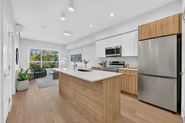 Kitchen with quartz island, white oak lowers and stainless appliances