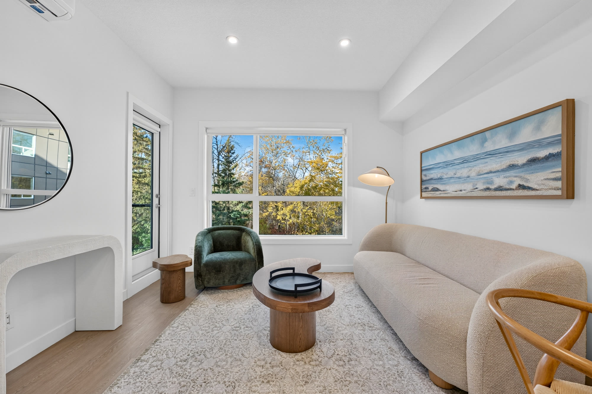 Living room in a Sanctuary residence with white oak floors and large windows onto the ravine trees
